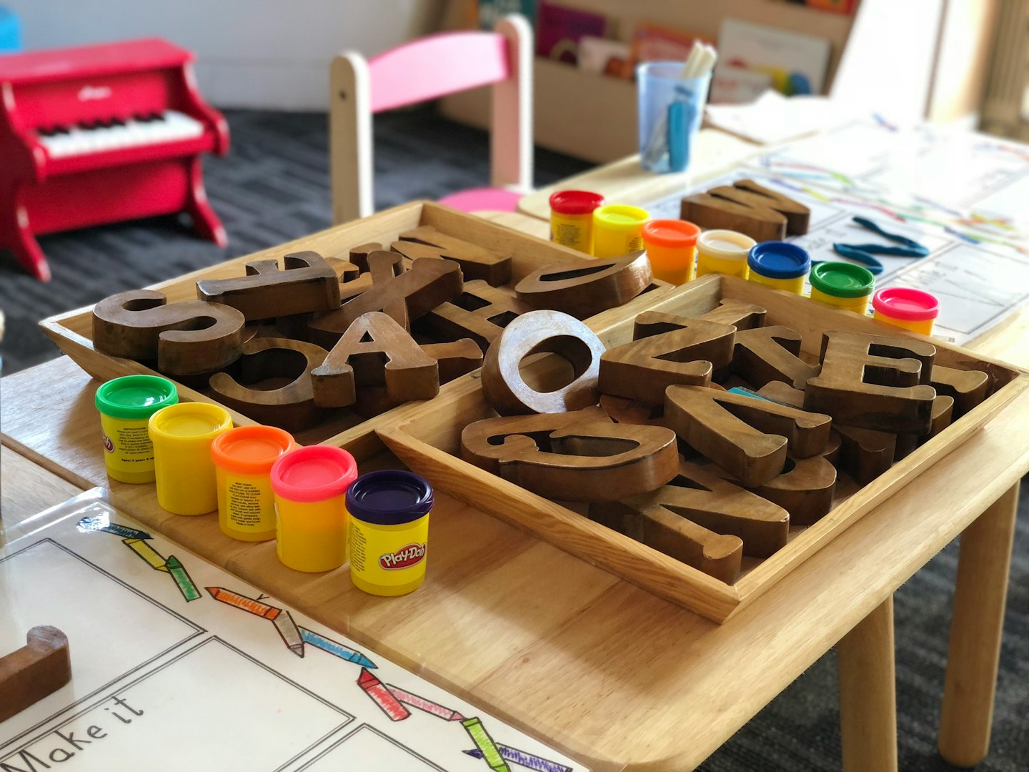 Children's activity table with letter blocks and Play-Doh.